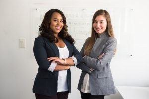 Two smiling women in gray and black coat | buildmywarrior Two smiling women in gray and black coat
