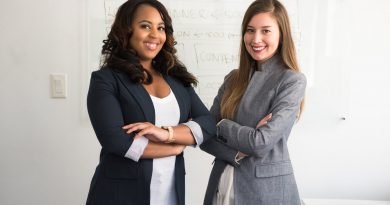 Two smiling women in gray and black coat