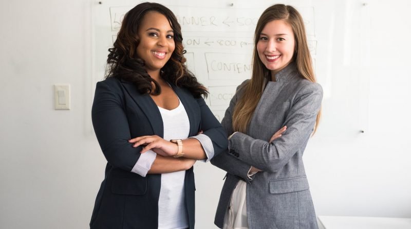 two smiling women in gray and black coat