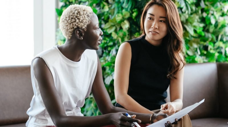 multi ethnic colleagues discussing contract on paper